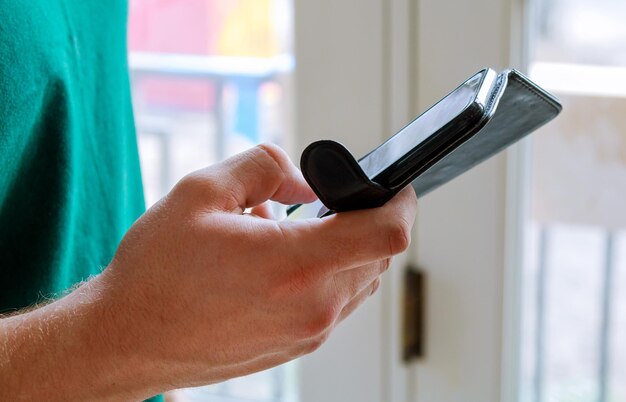 Close up of a man using mobile smart phone mobile phone in man hand