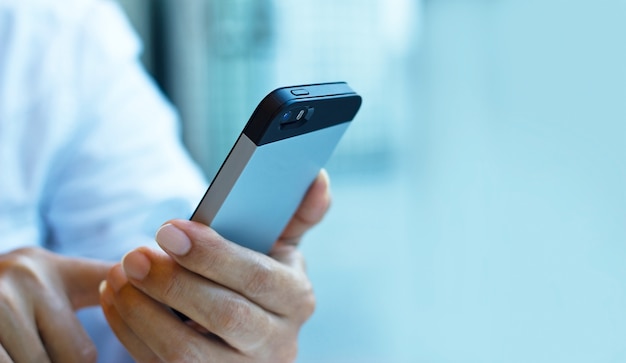 Close up of a man using mobile smart phone on pastel color tone