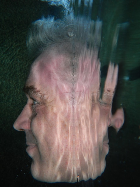 Photo close-up of man with reflection on water in pool