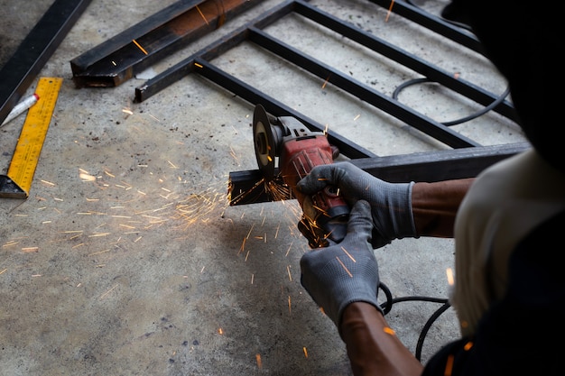 Close up, A man working with angle grinder. Iron gate repair