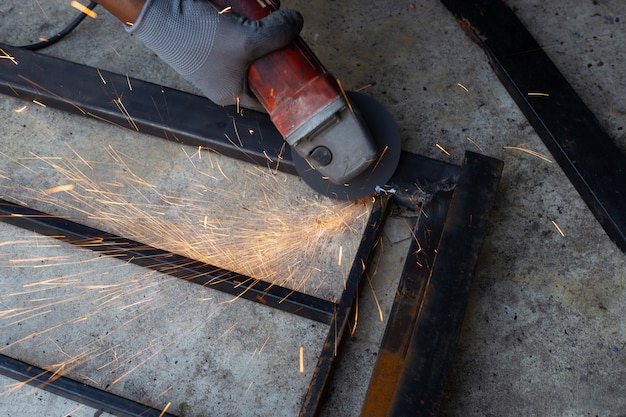 Close up, A man working with angle grinder. Iron gate repair