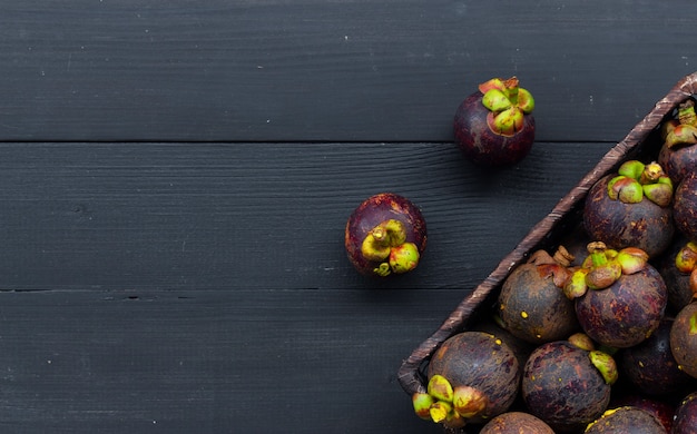 Photo close up of mangosteen fruit on black wood table