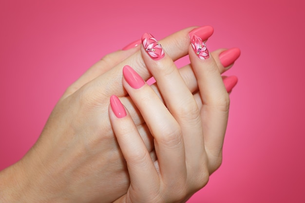 Photo close up on manicured woman's nails with pink nail art