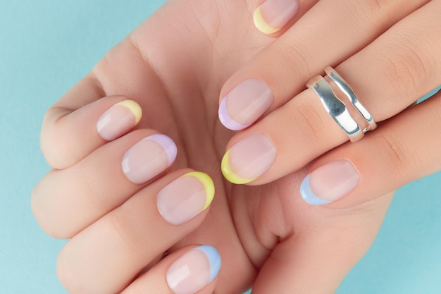 Close up manicured womans hands on blue background