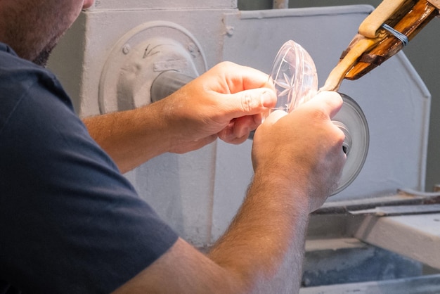 Close up mans hand making a glass carving on the new vase