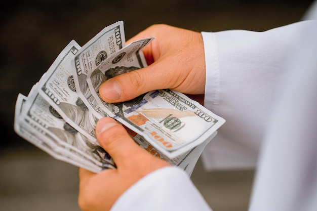 Close up of mans hands counting money