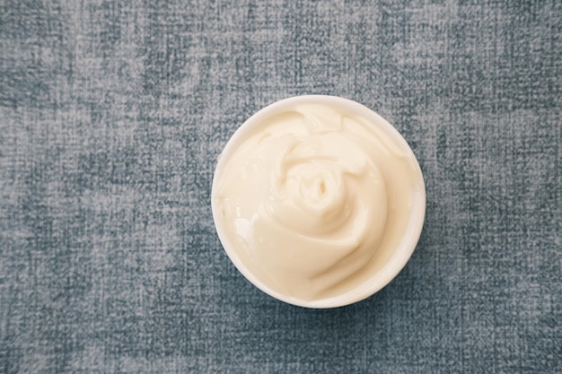 Close up of mayonnaise in container on table