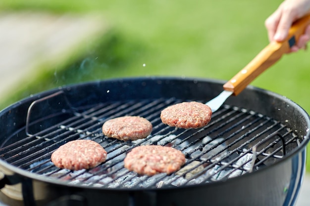 close up of meat cutlets roasting on grill