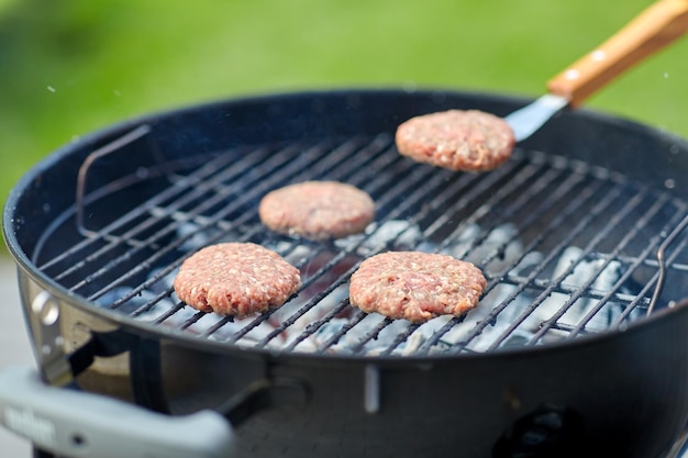 close up of meat cutlets roasting on grill