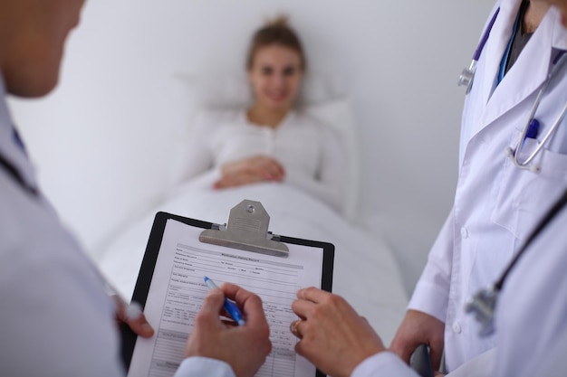 Close up of medical history, patient in the background.