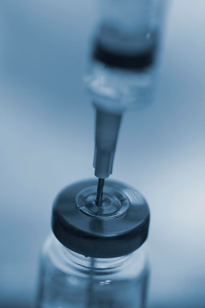 Close up of a medical injection needle in a vaccine vial dose