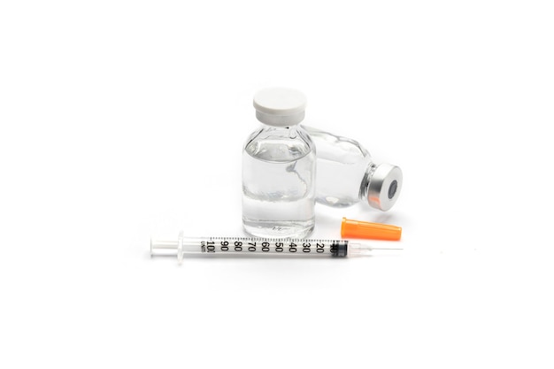 Close up medical or vaccine vial for injection with a syringe isolate on white surface.