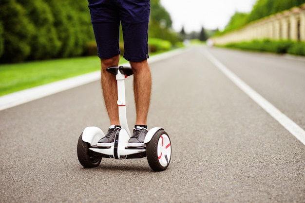 Close up. Men's legs in gray sneakers on a gyroboard.