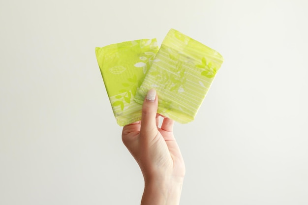 close-up of menstruation pads in hand on gray background