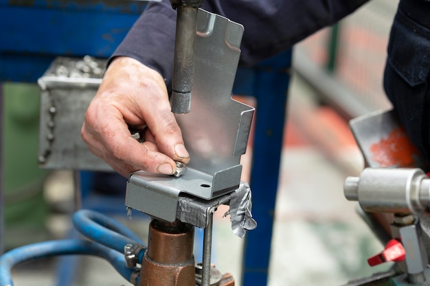 Photo close up of a metal element being spot-welded by a factory worker. industry concept.