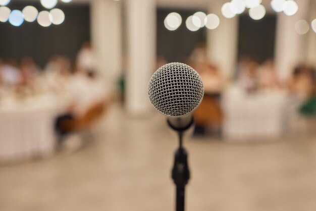 Photo close up of microphone in concert hall or conference room