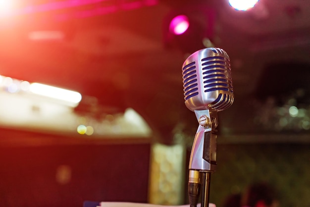 Close up of microphone on stage at outdoor night party abstract bokeh light background