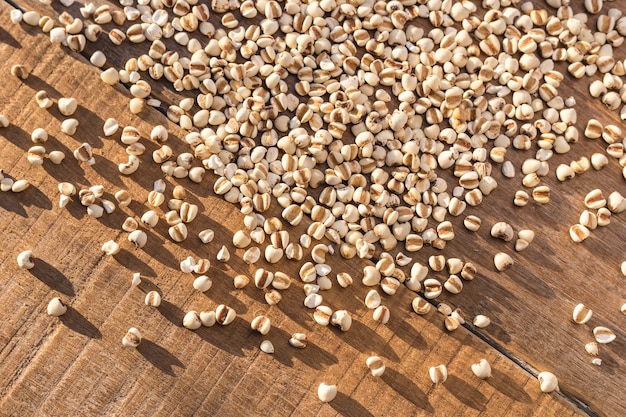 Close up millet rice or millet grains in small sack on wooden table