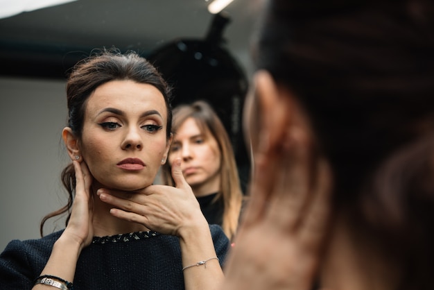 Close up mirror reflection of caucasian brunette woman in little black dress