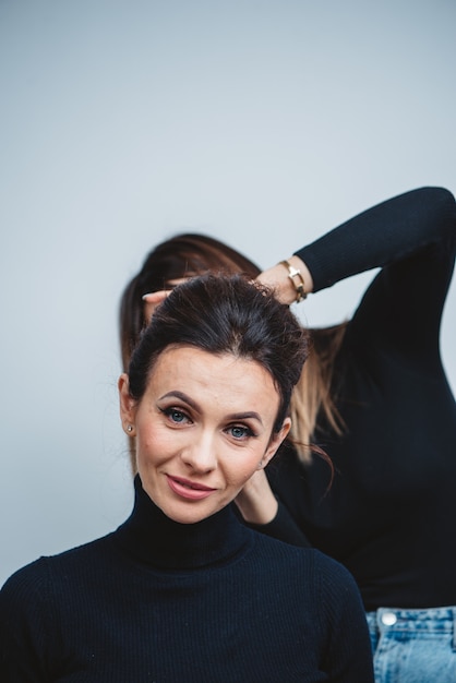 Close up mirror reflection of pretty face of young caucasian brunette woman in little black dress