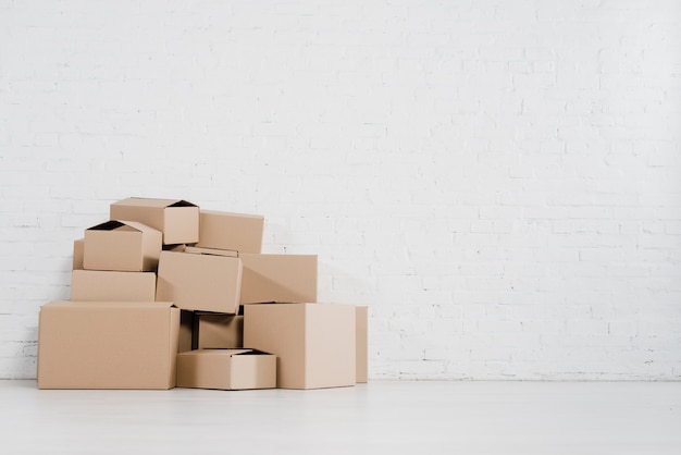 Close-up of moving cardboard boxes standing against brick wall