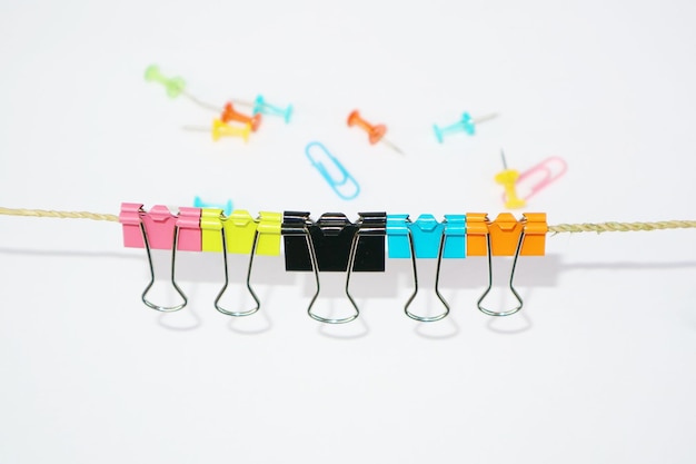 Close-up of multi colored clothespins hanging on white background