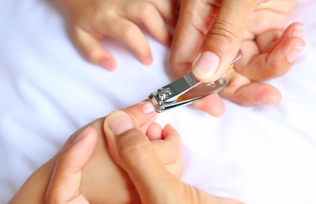 Close up of mum cutting babies nails