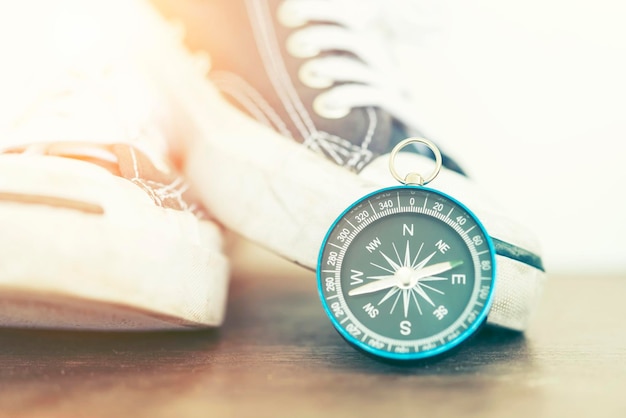 Photo close-up of navigational compass with shoes on table