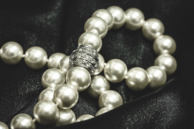 Close up of a necklace of white pearls with a luxury clasp