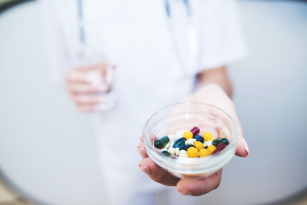 Close up  A nurse is holding various pills in her hands 