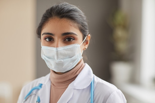 Close-up of nurse in protective mask looking at front standing at hospital