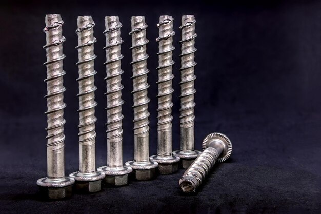 Close-up of nuts and bolts on table against black background