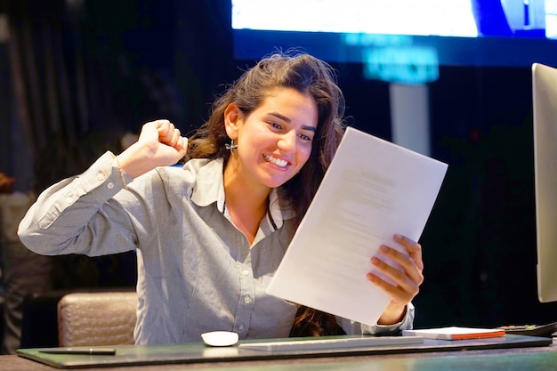 Close-up of an office worker. Happy lady, enjoying the good news in writing. An euphoric girl is happy after reading good news in a written letter, approving a loan, raising her job.