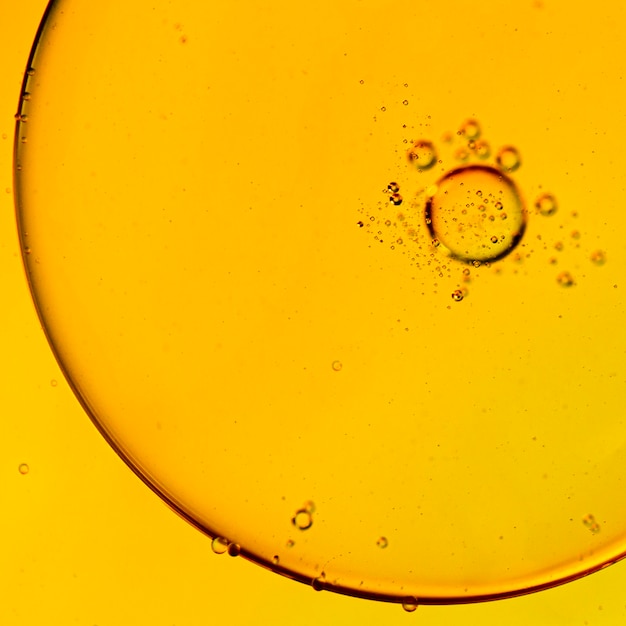 Close-up oily bubbles and droplets in colourful watery backdrop