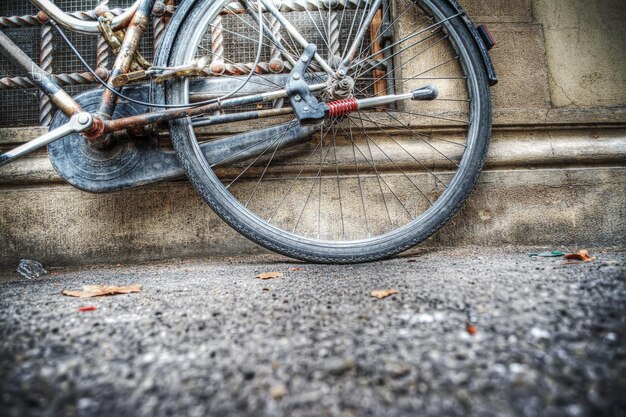 Close up of an old bicycle rear wheel agsinst a rustic wall