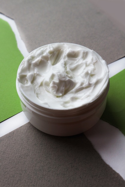 Close-up of open jars of face creams on a gray background