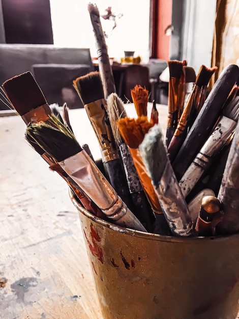 Photo close-up of paintbrushes in container on table