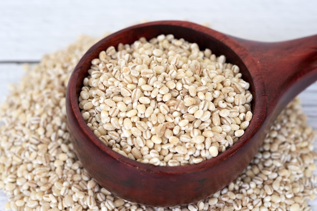 Close up of pearl barley in wooden scoop