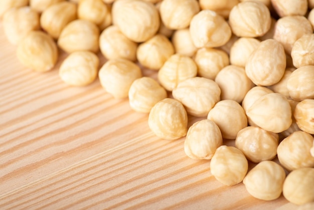 Close up of peeled hazelnuts on wooden background