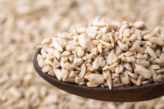 Close up of peeled sunflower grain in dark wooden spoon Fresh harvested sunflower seeds