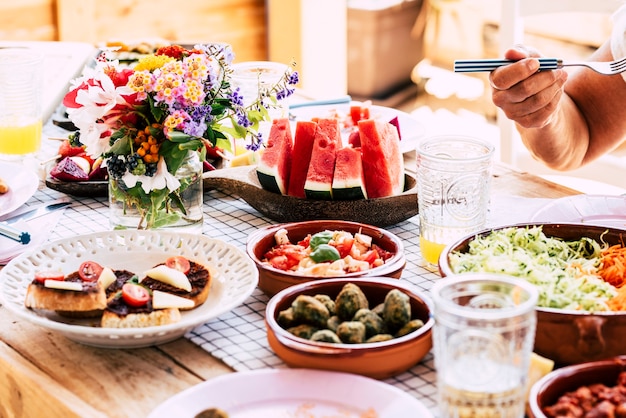 Close up of people eat healthy and vegetarian or vegan food on the table