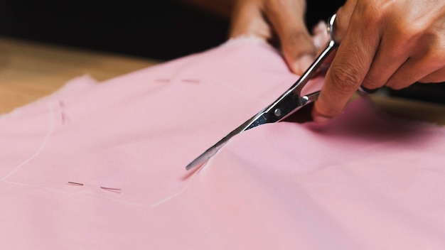 Close-up person cutting a fabric material