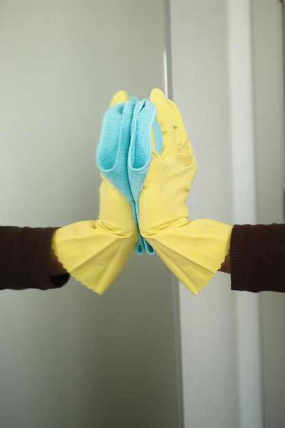 Close up of person hand in gloves cleaning window glass