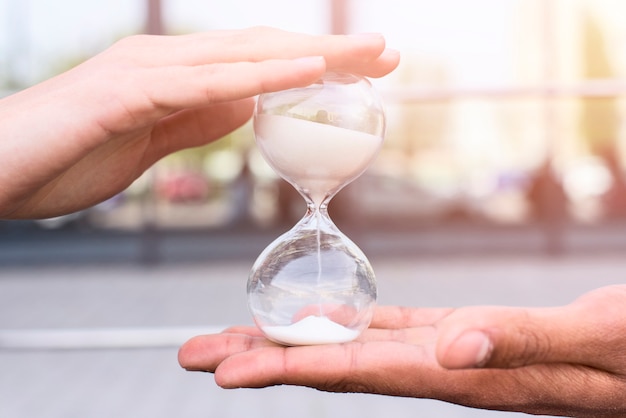 Close-up of person's hand holding hourglass