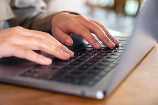 Photo close-up of person using laptop on table