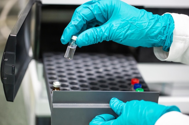 Close up of pharmacist hands with developed vaccine a drugs production and develop concept