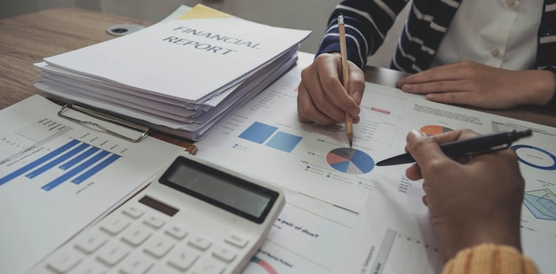 Close up photo of business working group of people are discussing together pointing at financial report top or above view