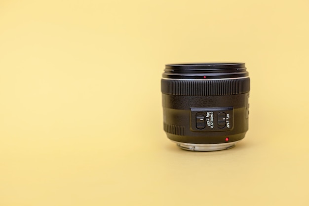 Close-up of a photo of a camera lens on a yellow background