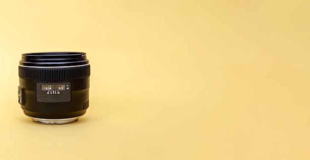 Close-up of a photo of a camera lens on a yellow background