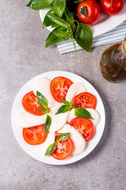 Close-up photo of caprese salad with ripe tomatoes, basil, buffalo mozzarella cheese.